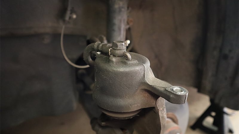 A close-up of the back of the caliper, showing the bolt that secures the flexible brake hose to the caliper.