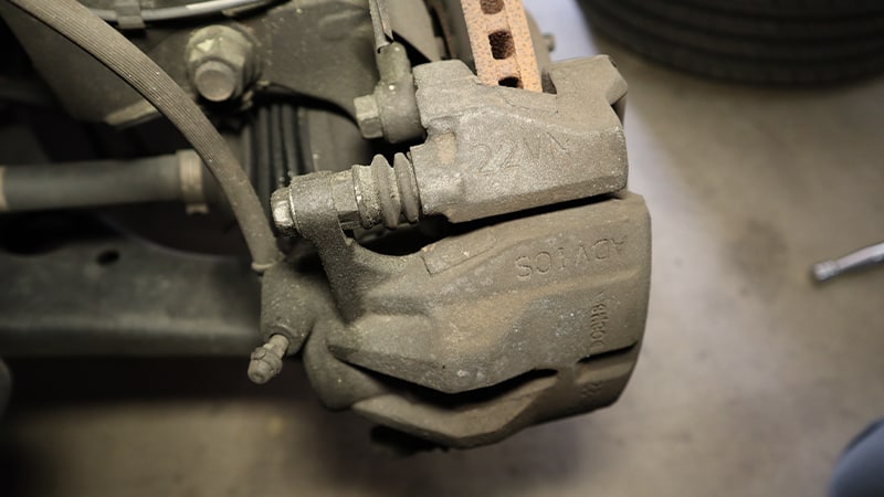 A view of the caliper from inside the wheel well, showing the bolts and bleeder screw locations.