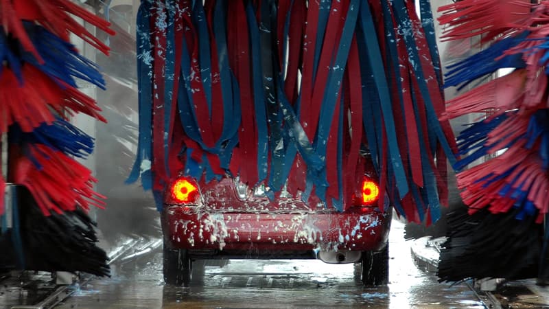 rear view of a red car going through a car wash