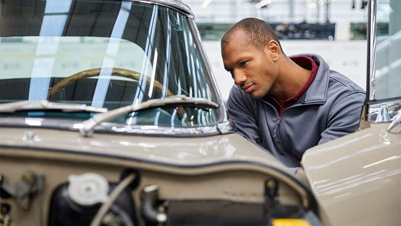 a man inspecting a classic car