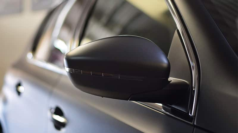 closeup of a matte black wrap on a side mirror