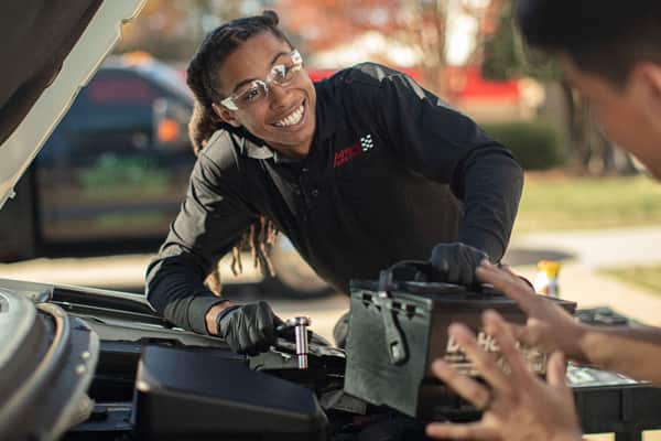 Employee assisting customer with new battery installation